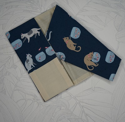 Protège carnet de santé animaux tissu bleu foncé avec des chats marrons, blancs et gris jouant avec des poissons dans un aquarium